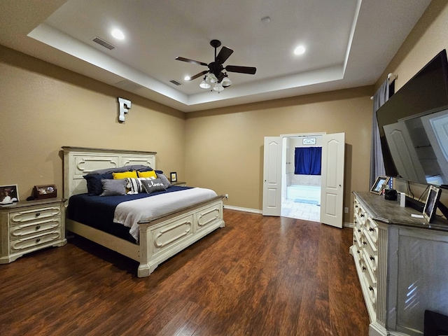 bedroom with recessed lighting, a raised ceiling, dark wood-style floors, and visible vents