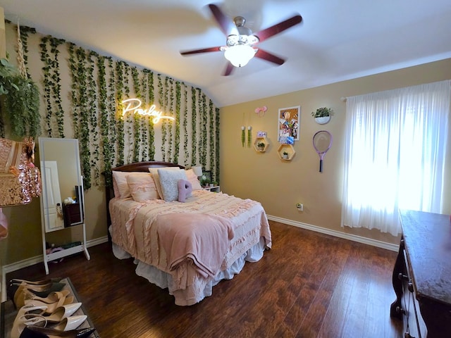 bedroom featuring baseboards, ceiling fan with notable chandelier, wood finished floors, and vaulted ceiling