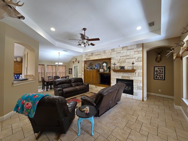 living room with visible vents, a ceiling fan, a raised ceiling, and baseboards