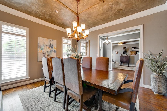 dining room featuring ornamental molding, a notable chandelier, baseboards, and wood finished floors