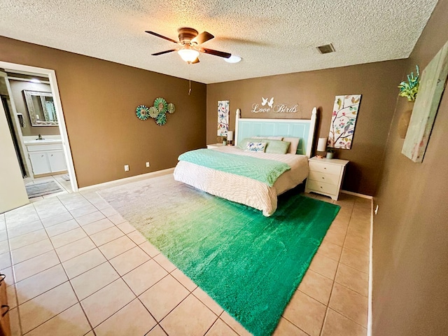 tiled bedroom featuring sink, connected bathroom, a textured ceiling, and ceiling fan