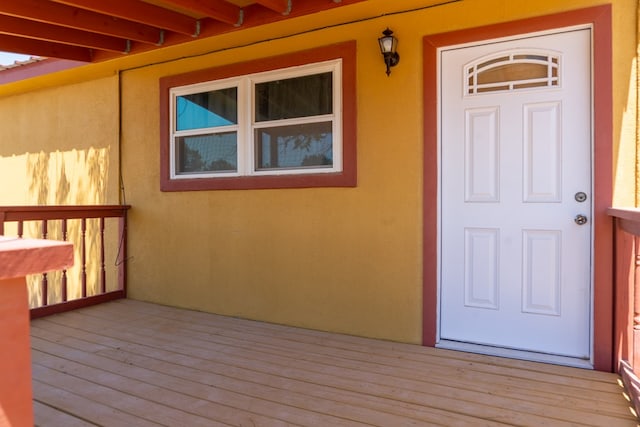 view of exterior entry with a wooden deck