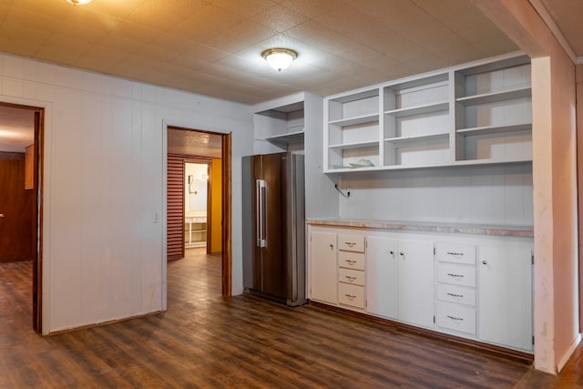 kitchen featuring high quality fridge, wooden walls, dark hardwood / wood-style flooring, and white cabinets