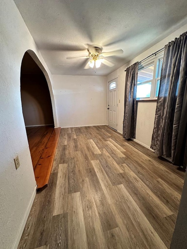 empty room featuring a textured ceiling, hardwood / wood-style flooring, and ceiling fan