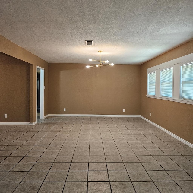 801 W Golf Course Rd, Midland, TX 79701 - unfurnished room featuring a textured ceiling, a chandelier, and baseboards