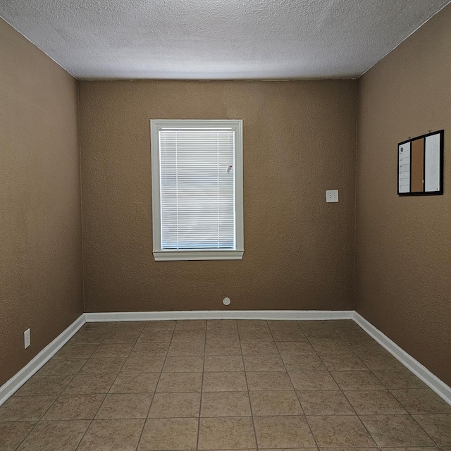 801 W Golf Course Rd, Midland, TX 79701 - tiled spare room with baseboards and a textured ceiling