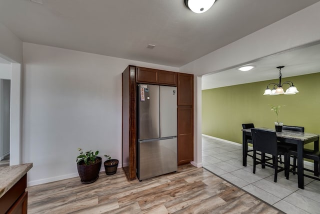 3004 W 4th, Odessa, TX 79763 - kitchen with freestanding refrigerator, pendant lighting, light wood finished floors, a chandelier, and light countertops