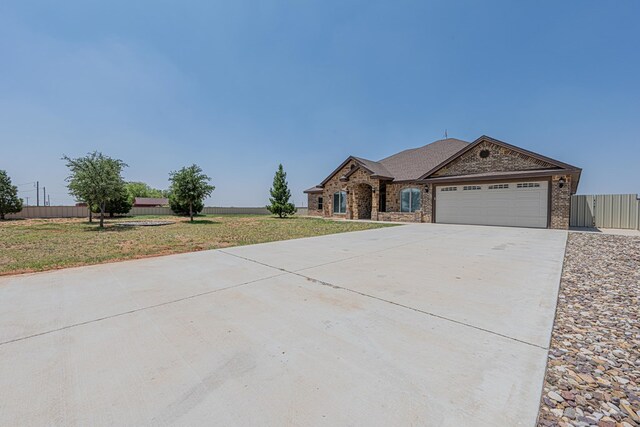 2894 SE 5001, Andrews, TX 79714 - view of front facade featuring a garage, driveway, and brick siding