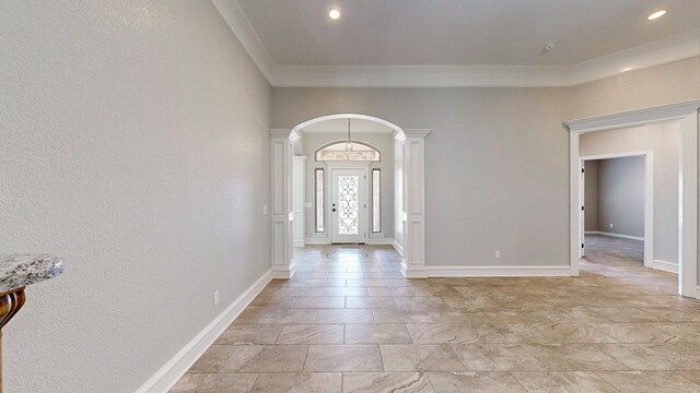 2894 SE 5001, Andrews, TX 79714 - entrance foyer with ornate columns, arched walkways, crown molding, light stone finish flooring, and baseboards