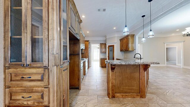 2894 SE 5001, Andrews, TX 79714 - kitchen featuring brown cabinets, a peninsula, a kitchen bar, stone tile floors, and ornamental molding