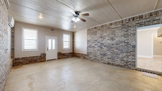 2894 SE 5001, Andrews, TX 79714 - entryway with brick wall, ceiling fan, concrete flooring, and an AC wall unit
