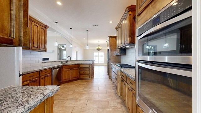 2894 SE 5001, Andrews, TX 79714 - kitchen featuring stainless steel appliances, a peninsula, backsplash, brown cabinetry, and crown molding
