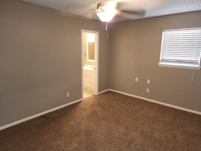 carpeted empty room featuring ceiling fan and a textured ceiling