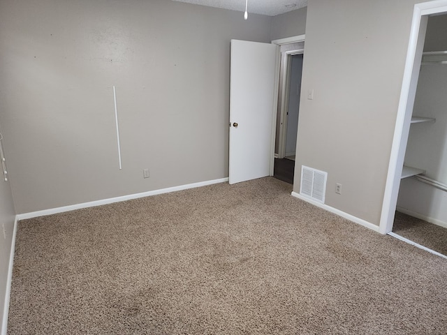 unfurnished bedroom featuring carpet floors and a closet