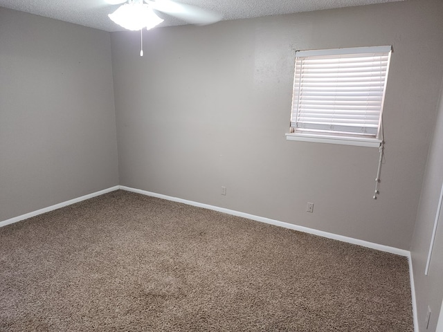 carpeted empty room with ceiling fan and a textured ceiling