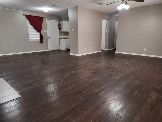 unfurnished living room featuring ceiling fan, dark hardwood / wood-style flooring, and a textured ceiling