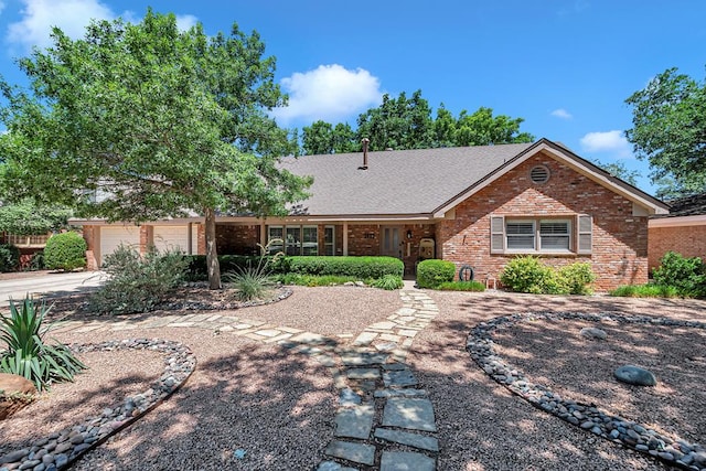 2512 Sinclair Ave, Midland, TX 79705 - view of front facade with brick siding, concrete driveway, an attached garage, and covered porch