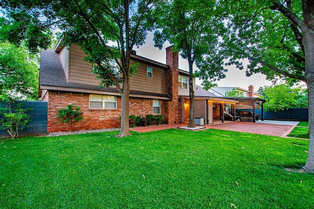 2512 Sinclair Ave, Midland, TX 79705 - rear view of house with a patio, brick siding, and a chimney