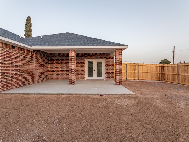 back house at dusk featuring a patio area and french doors