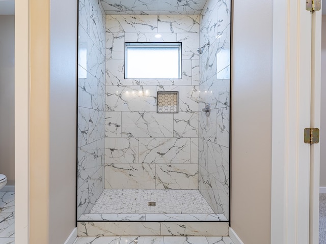 bathroom with toilet and a tile shower