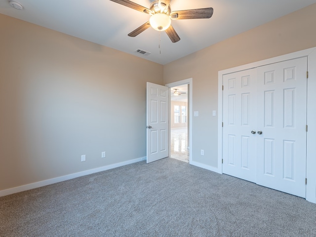 unfurnished bedroom featuring ceiling fan, a closet, and carpet flooring