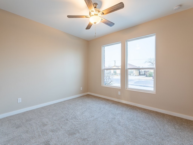 carpeted spare room with ceiling fan