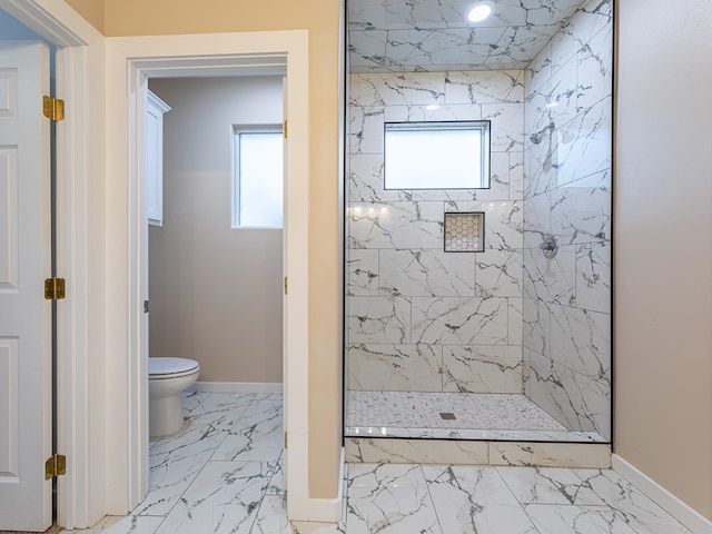 bathroom featuring toilet, plenty of natural light, and a tile shower