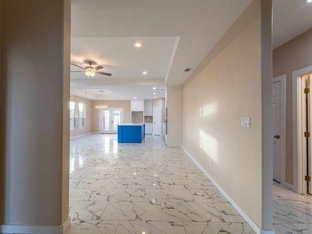 hallway featuring sink and a notable chandelier