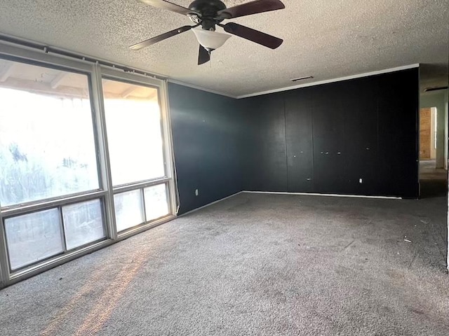 carpeted spare room with ceiling fan and a textured ceiling