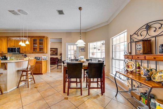 5500 Heartland Ct, Midland, TX 79707 - dining room featuring healthy amount of natural light, ornamental molding, light tile patterned flooring, and a textured ceiling