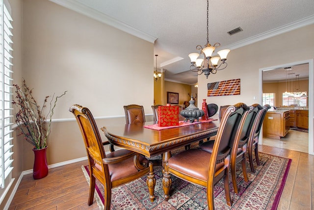 5500 Heartland Ct, Midland, TX 79707 - dining space featuring a chandelier, light wood finished floors, crown molding, and a textured ceiling