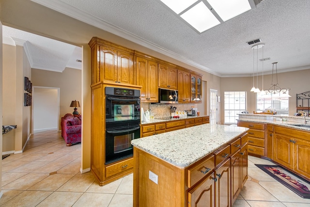 5500 Heartland Ct, Midland, TX 79707 - kitchen with black appliances, light tile patterned floors, a kitchen island, brown cabinets, and crown molding