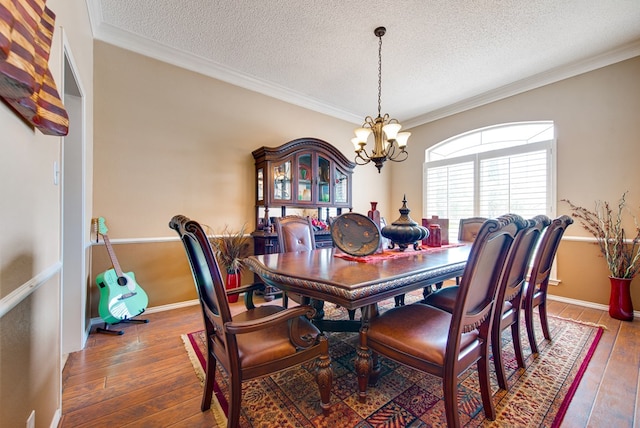 5500 Heartland Ct, Midland, TX 79707 - dining space with a textured ceiling, a chandelier, hardwood / wood-style flooring, and crown molding