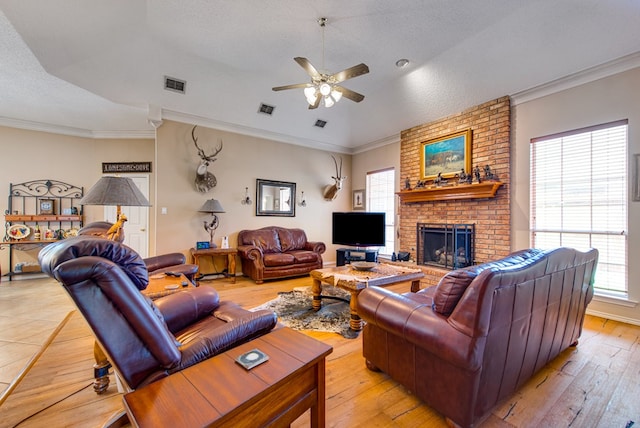 5500 Heartland Ct, Midland, TX 79707 - living area with ceiling fan, a fireplace, light wood-style flooring, ornamental molding, and a textured ceiling