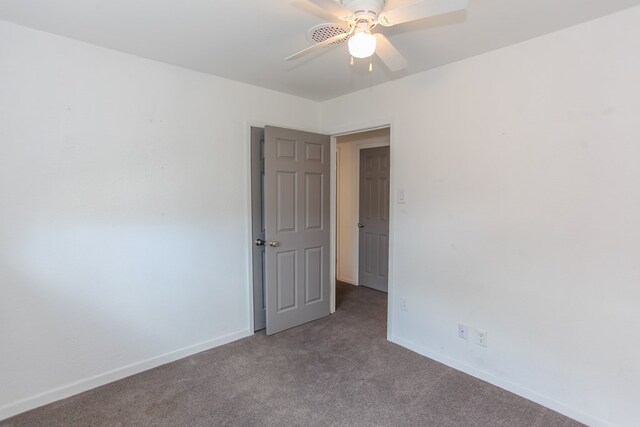 carpeted spare room with ceiling fan