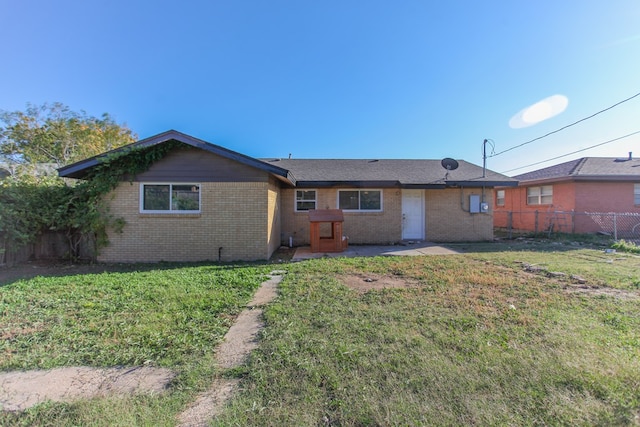 rear view of property featuring a lawn