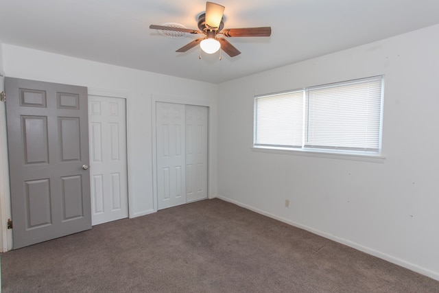 unfurnished bedroom featuring carpet floors, ceiling fan, and multiple closets