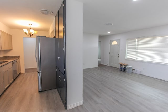 kitchen featuring dishwasher, hanging light fixtures, light hardwood / wood-style flooring, stainless steel fridge, and a notable chandelier