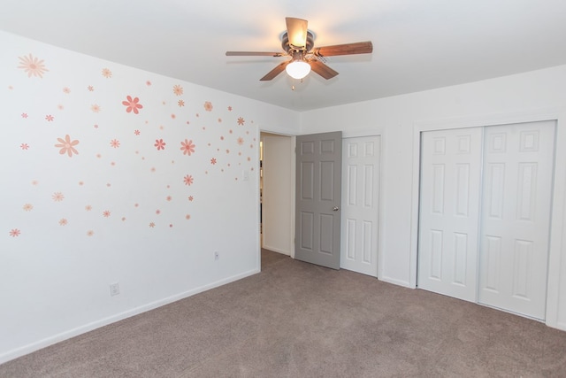 unfurnished bedroom featuring carpet, ceiling fan, and two closets