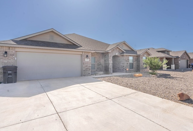 view of front of home featuring driveway, brick siding, roof with shingles, and an attached garage