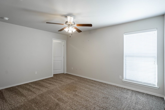 unfurnished room with a ceiling fan, carpet, and baseboards