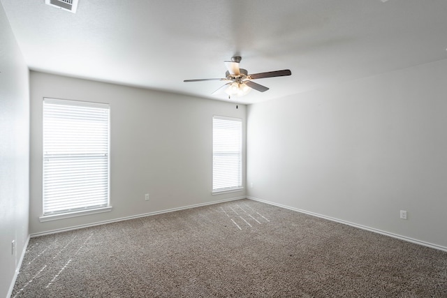 unfurnished room featuring visible vents, carpet floors, a ceiling fan, and baseboards