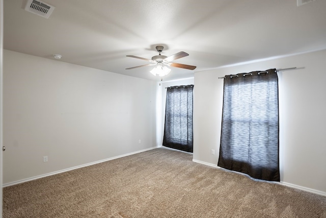 spare room featuring baseboards, visible vents, ceiling fan, and carpet flooring