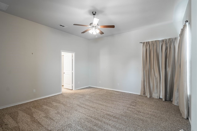 spare room with carpet, visible vents, ceiling fan, and baseboards