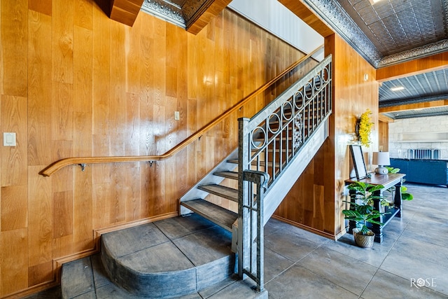 stairway featuring a stone fireplace and wooden walls