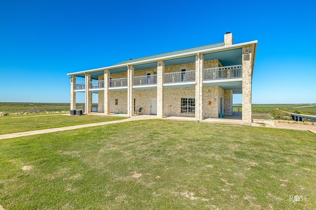 back of house with a lawn, central air condition unit, and a balcony