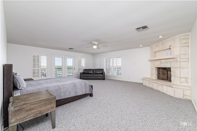 bedroom with carpet, ceiling fan, access to exterior, and a fireplace