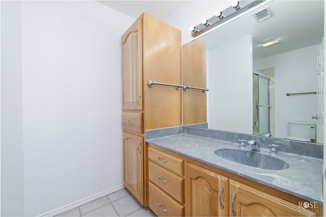 bathroom featuring tile patterned floors, vanity, toilet, and walk in shower