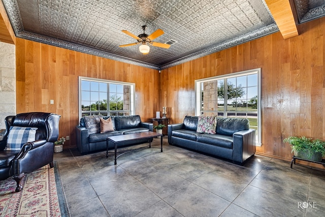 interior space with wood walls, ceiling fan, and ornamental molding