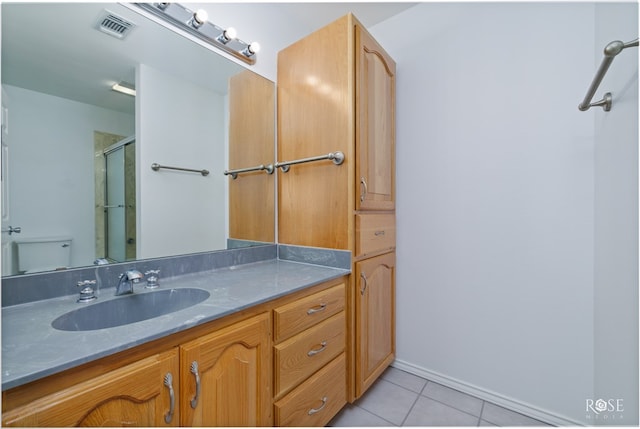 bathroom with tile patterned flooring, vanity, toilet, and walk in shower